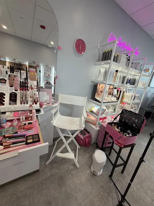 Where it is now: Dailin's studio with a white makeup chair and pink lit shelves
